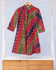 Display of green dress, with bold red and navy fish print.