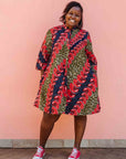 Model wearing green dress, with bold red and navy fish print.