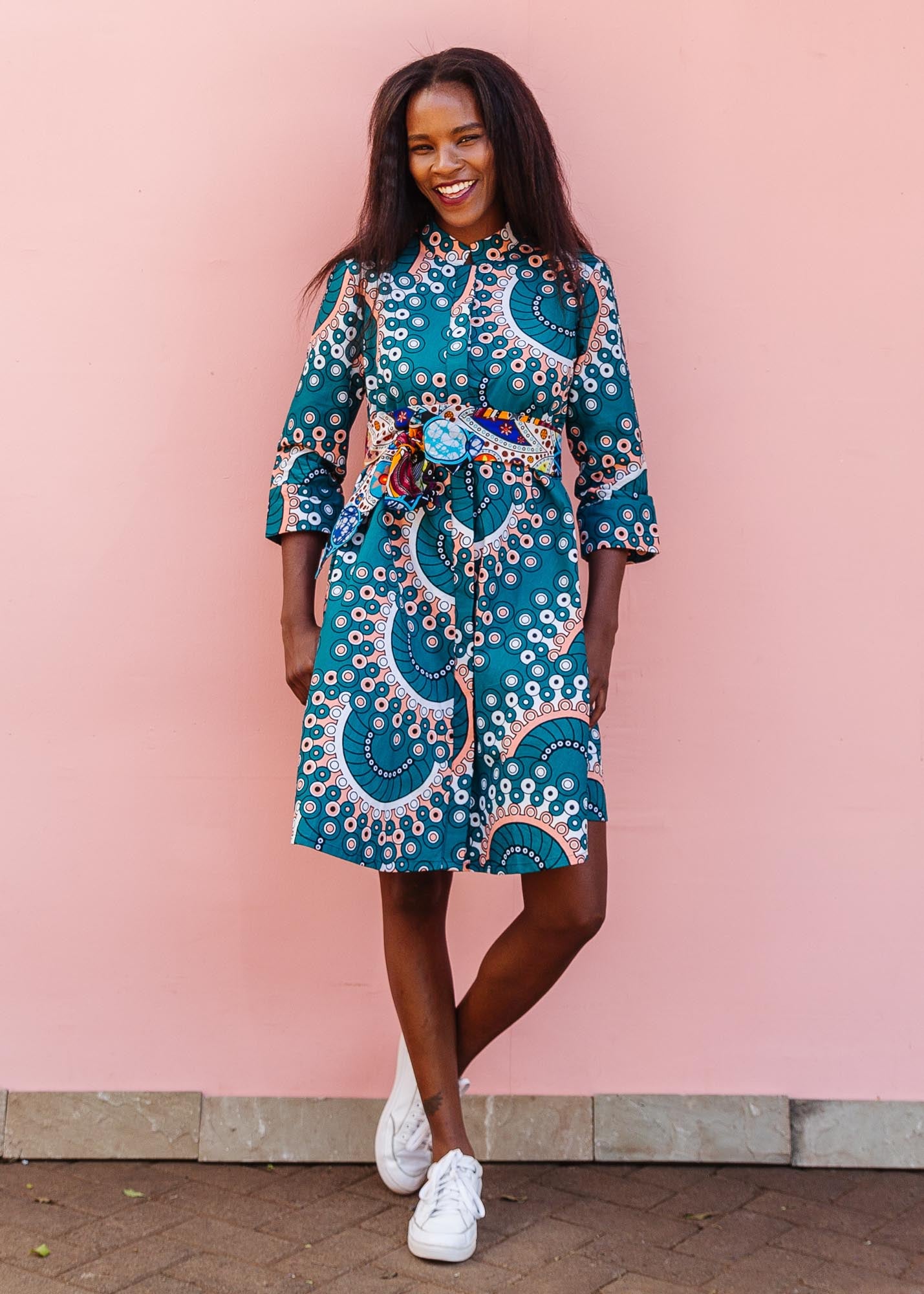 The model is wearing teal, white, black and peach dress with gears