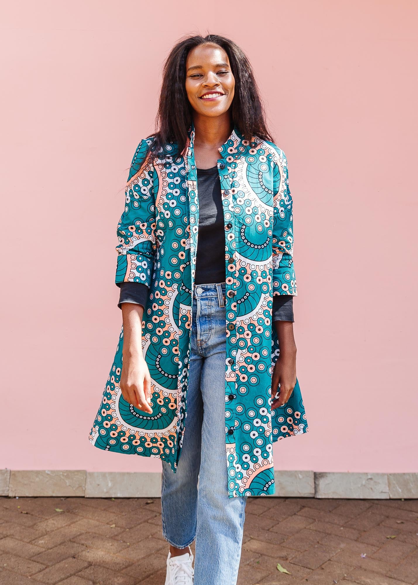 The model is wearing teal, white, black and peach dress with gears