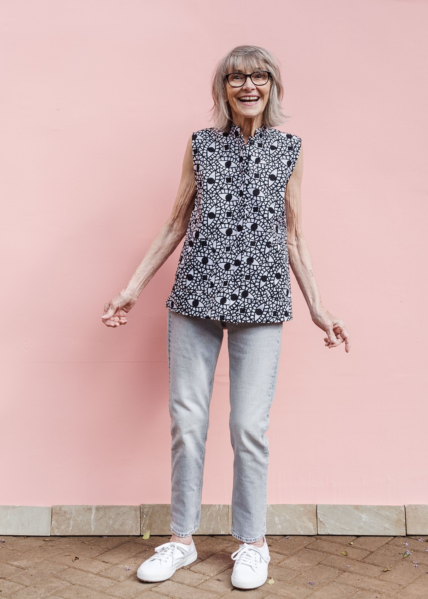 Model wearing black and white eye print sleeveless shirt.