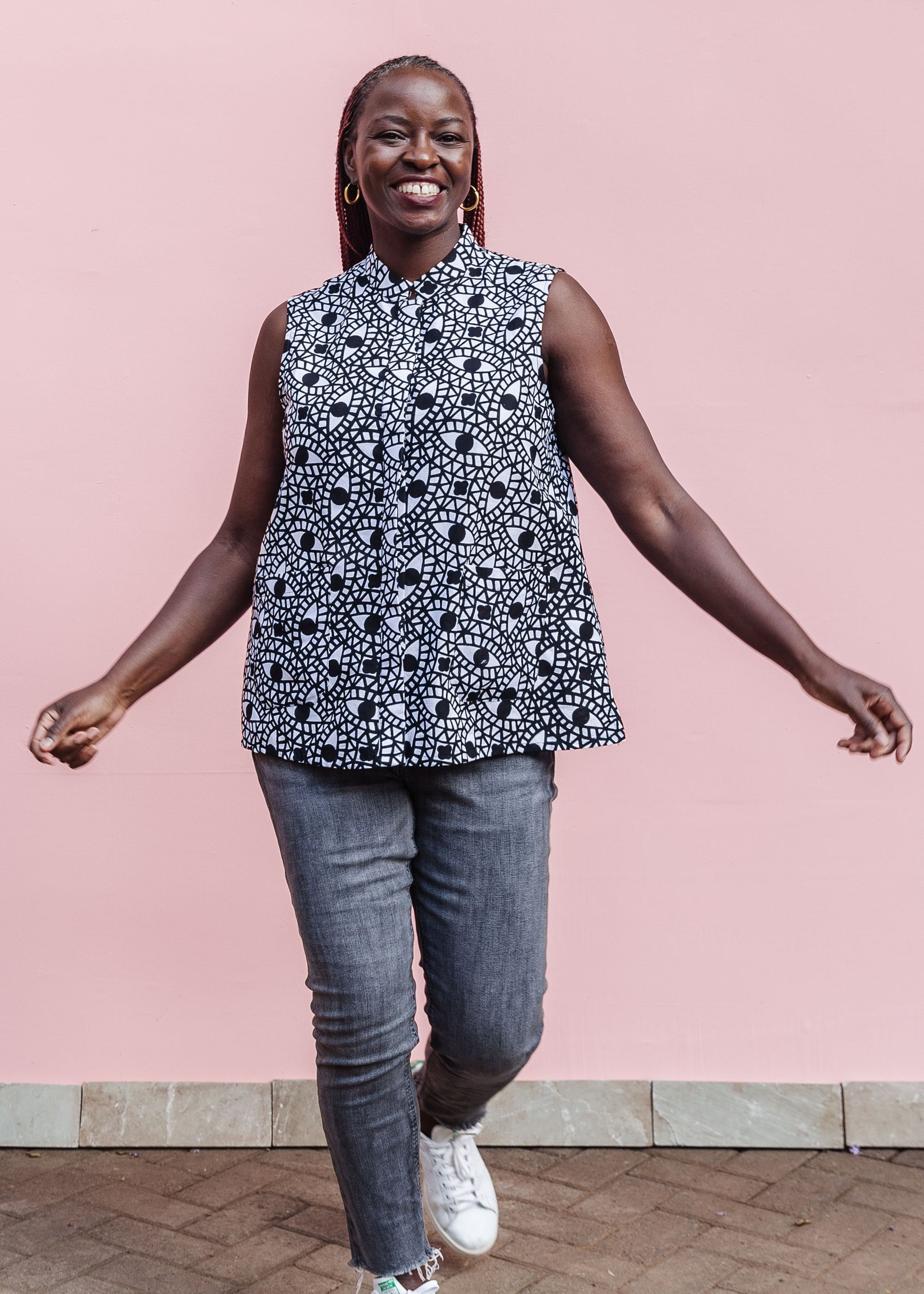 Model wearing black and white eye print sleeveless shirt.