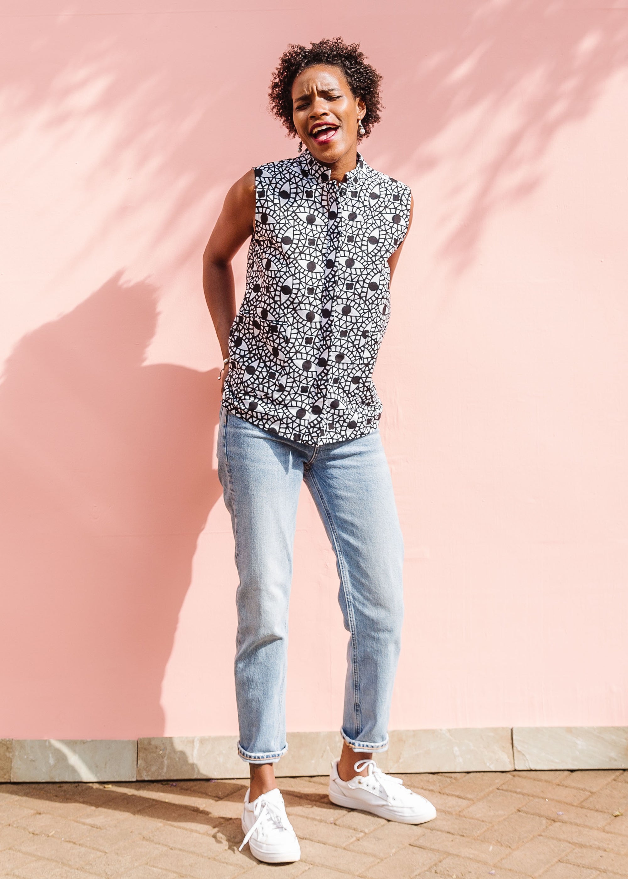 Model wearing black and white eye print sleeveless shirt.