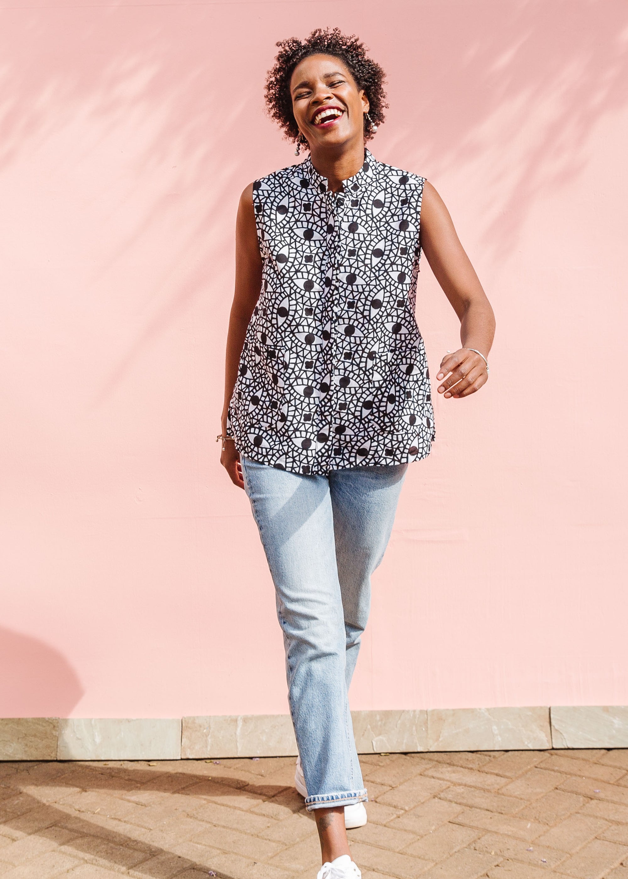 Model wearing black and white eye print sleeveless shirt.