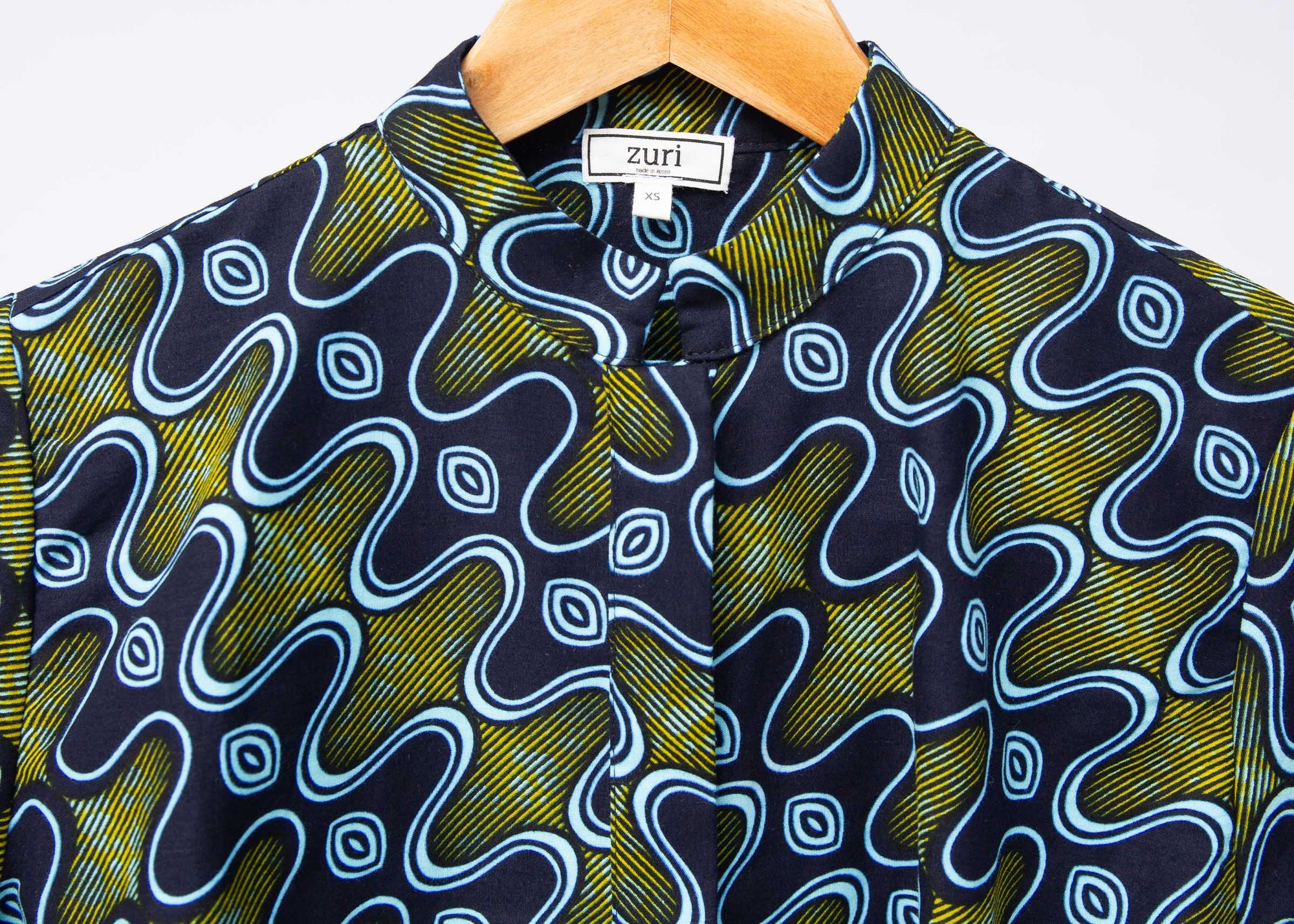 Display of long sleeved blue, green and yellow, zig zag print shirt.