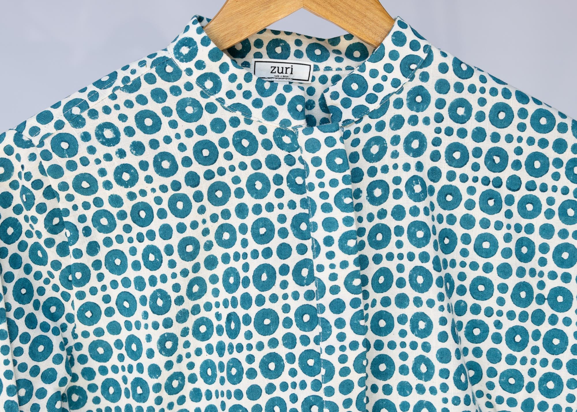 detail of teal and white block printed long sleeved shirt