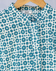 detail of teal and white block printed long sleeved shirt