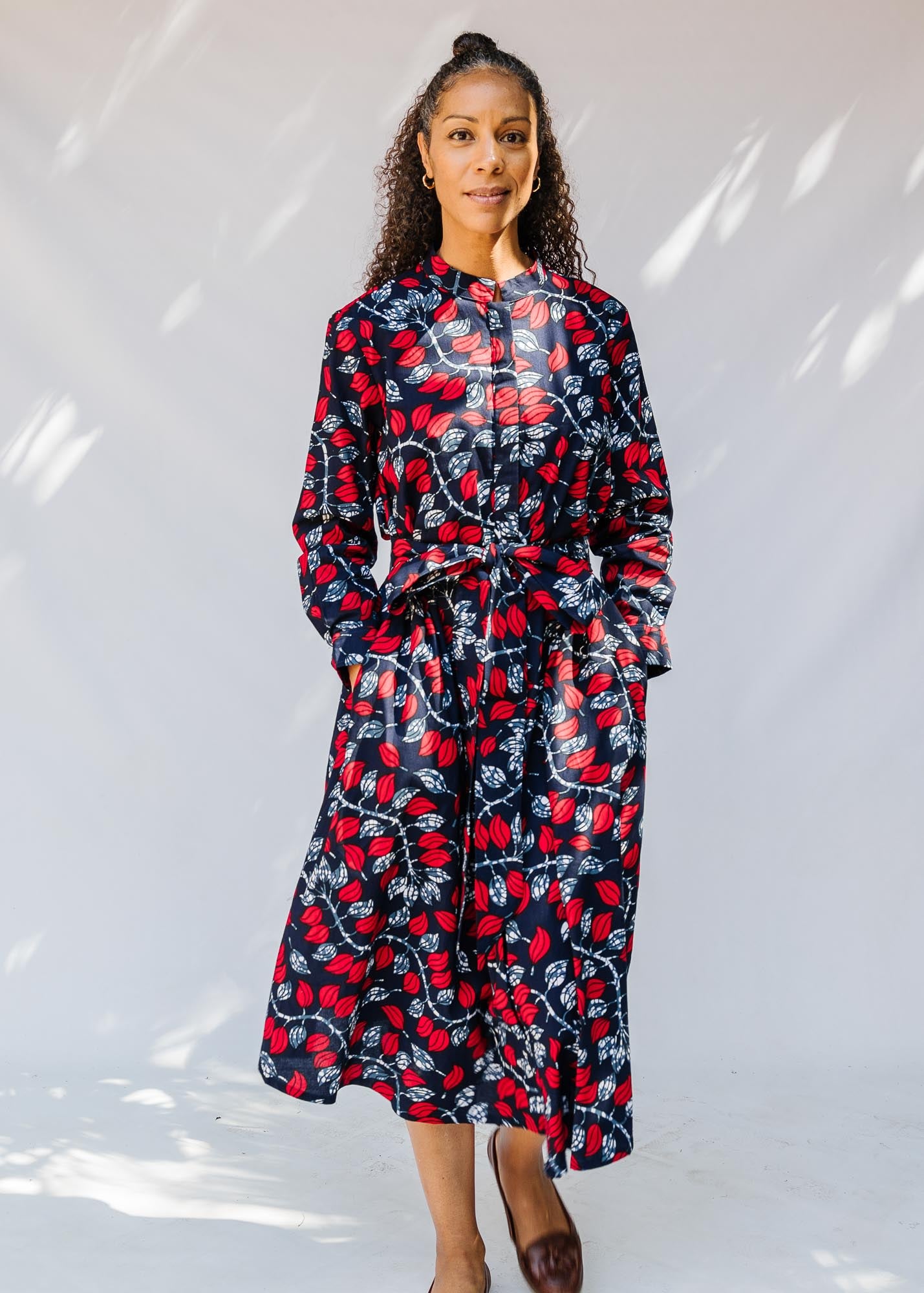 model wearing a red and navy belted midi-length dress