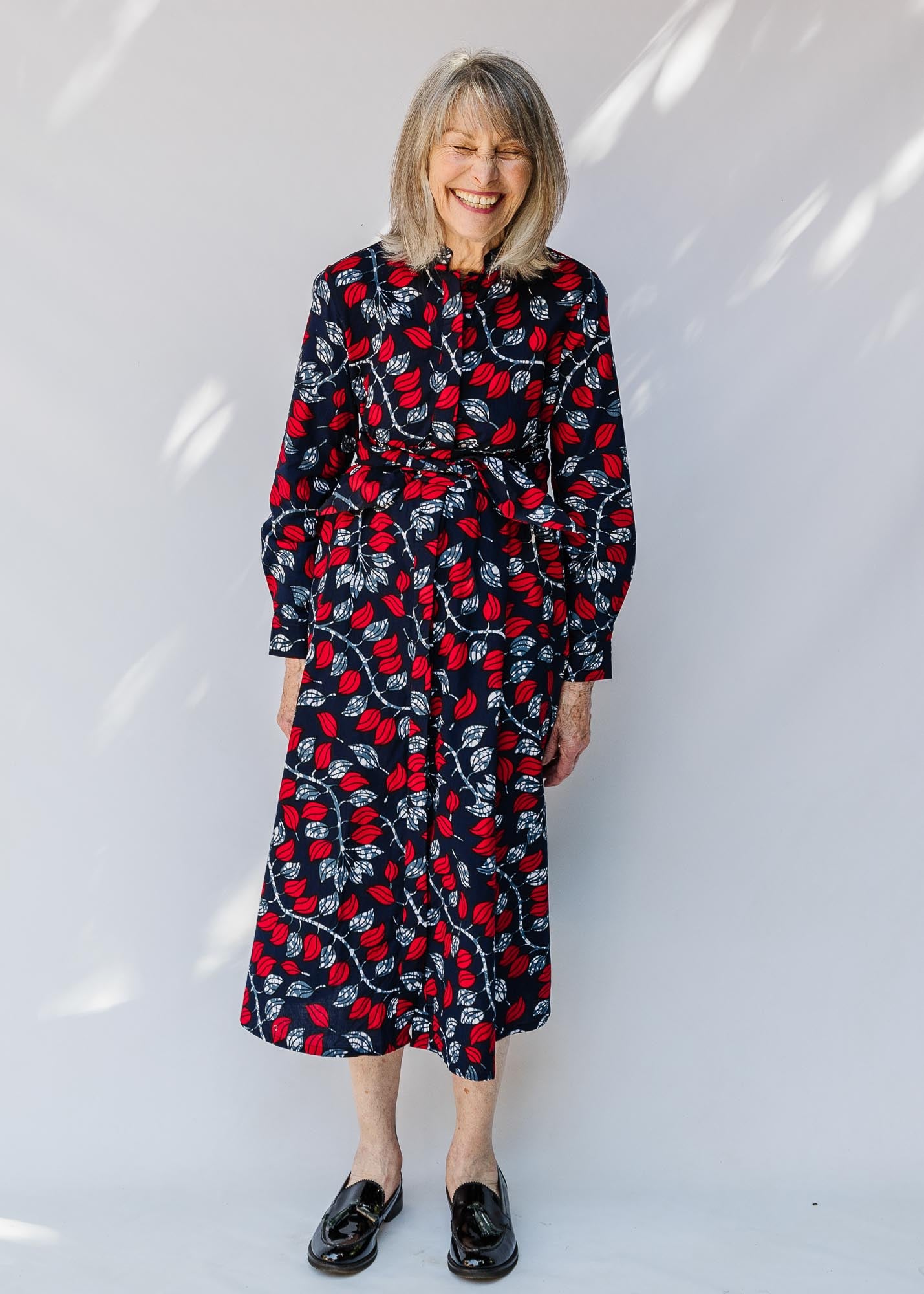 model wearing a red and navy belted midi-length dress