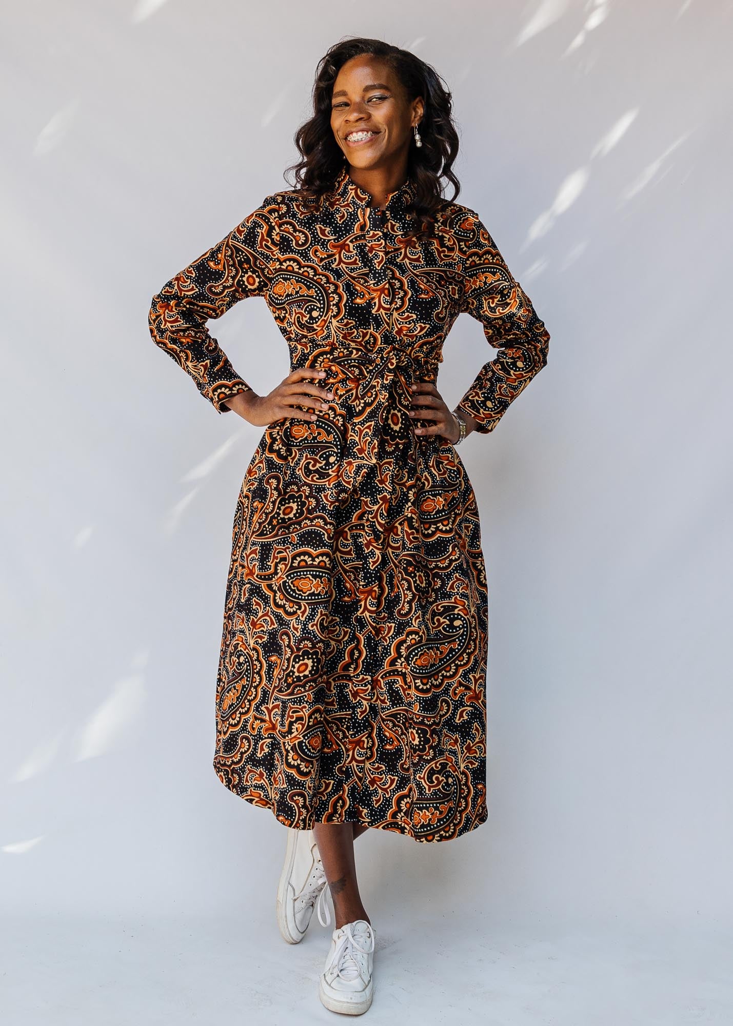 model wearing a midi-length belted paisley dress