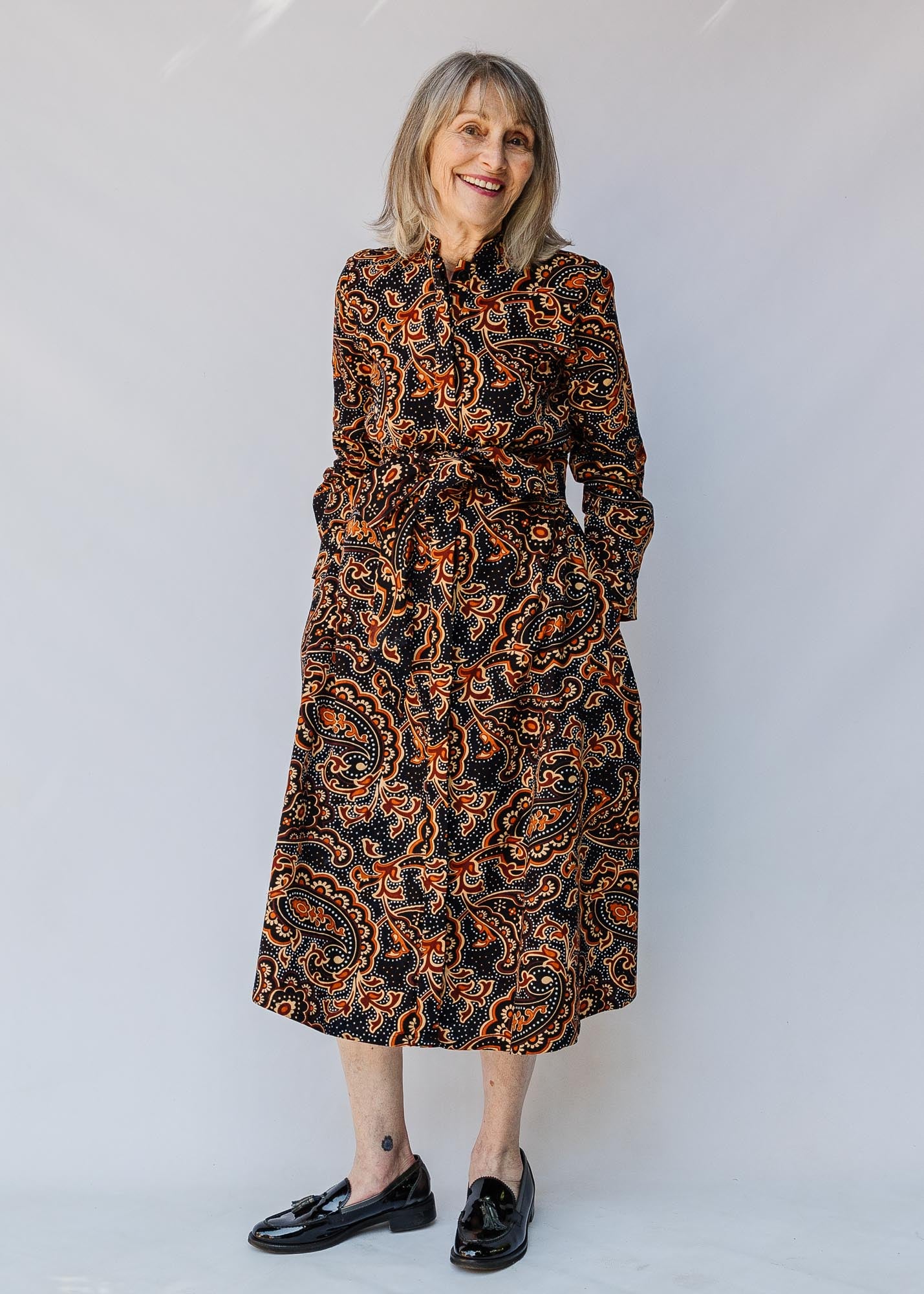 model wearing a midi-length belted paisley dress