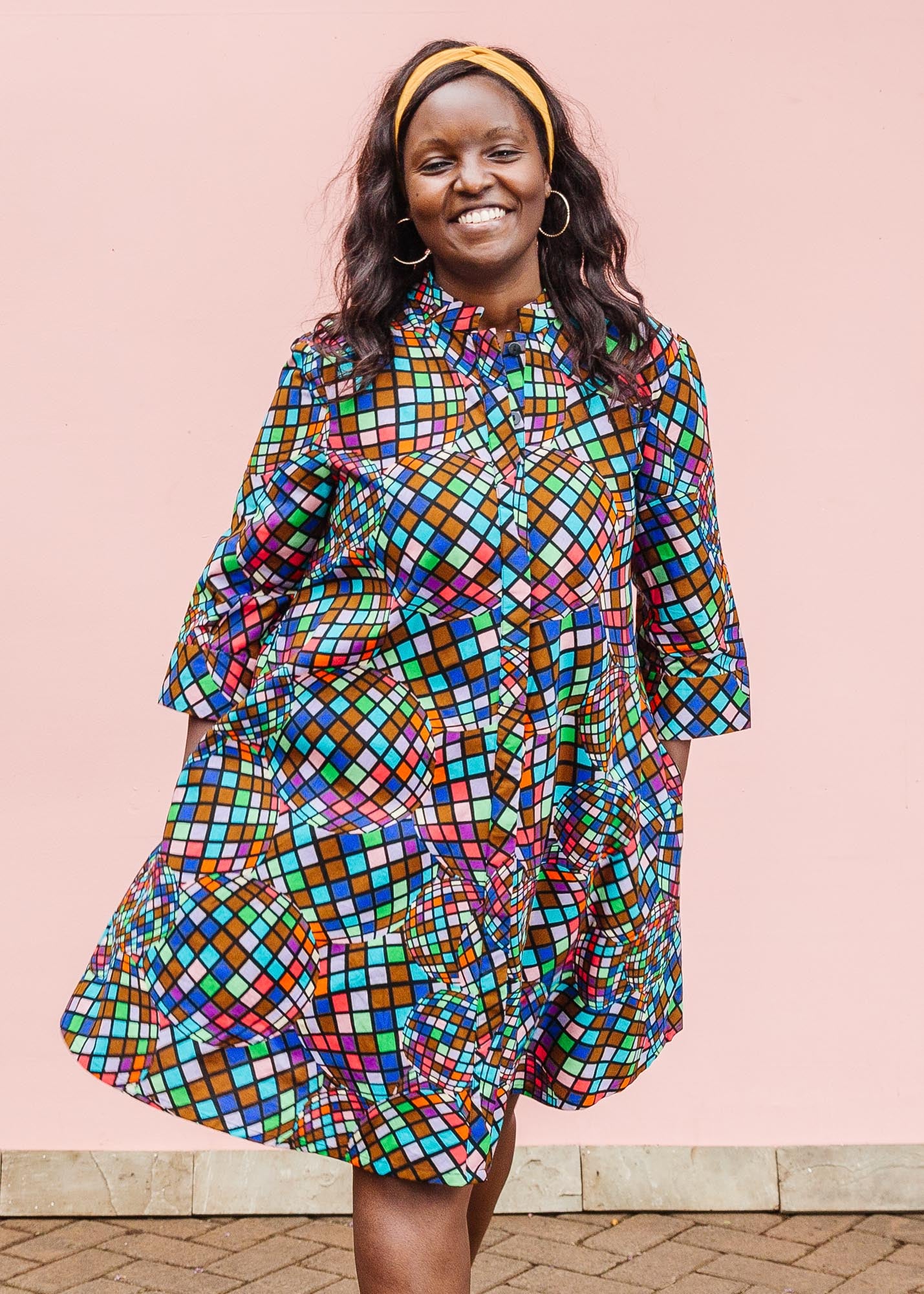 The model is wearing multi colored dress with disco ball print