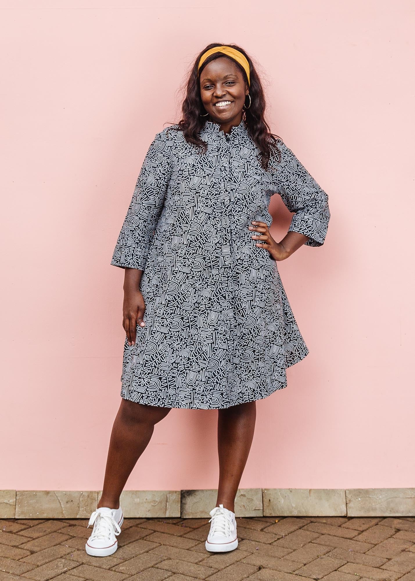 The model is wearing black and white doodle print dress