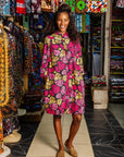 The model is wearing black, white, yellow, brown, pink, hot pink and purple bubble print dress