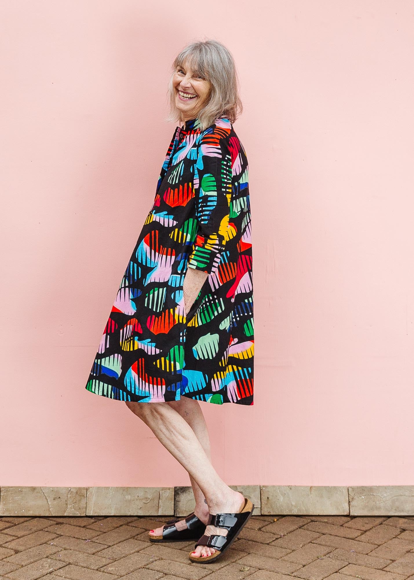 The model is wearing abstract multi-color  figures dress