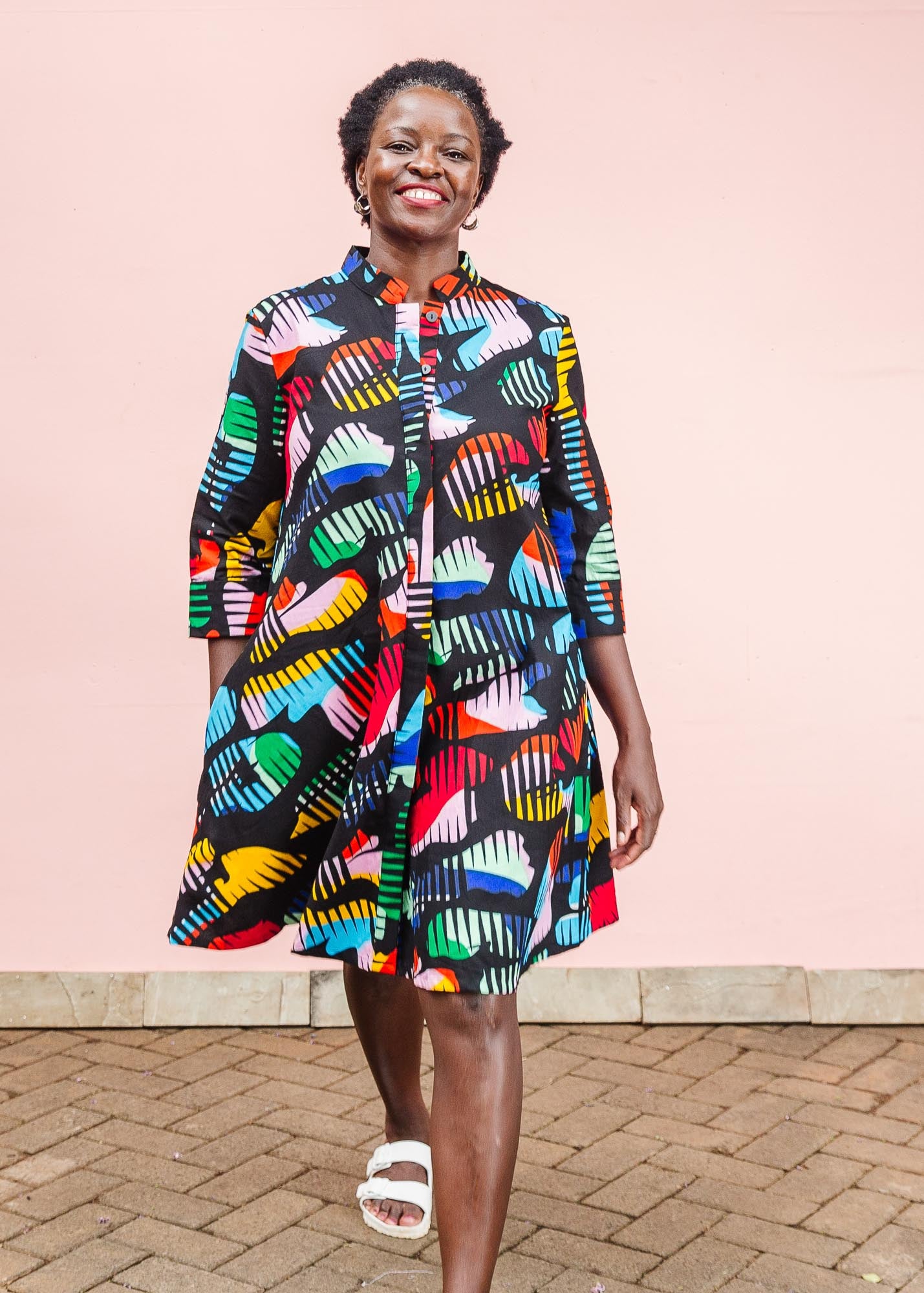 The model is wearing abstract multi-color  figures dress