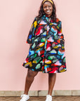 The model is wearing abstract multi-color  figures dress