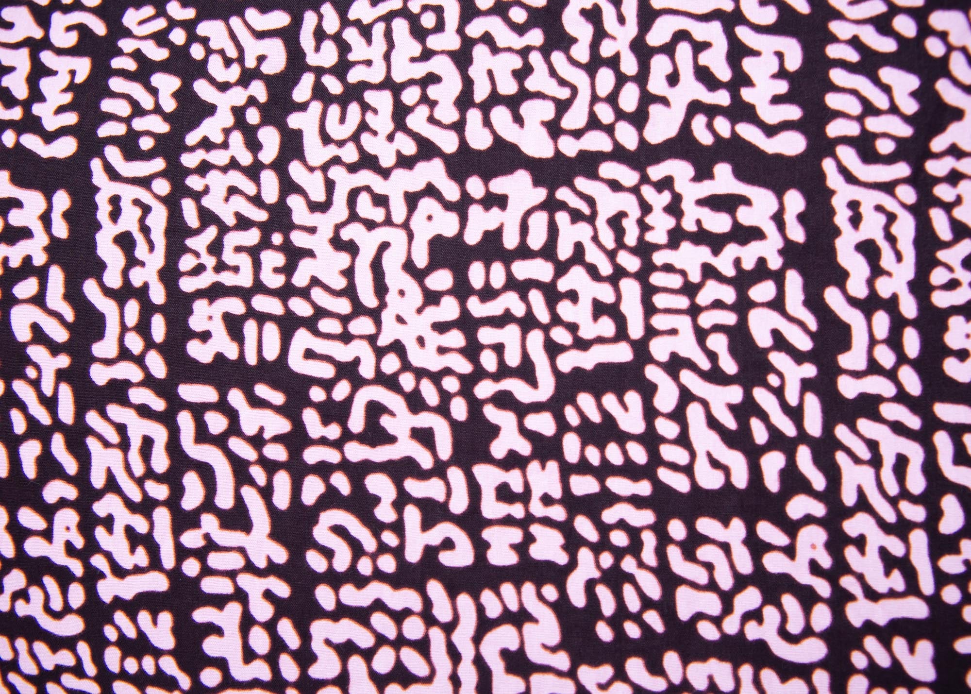 Close up display of brown and baby pink abstract print dress