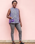 The model is wearing purple, lavender, black and white kanga tank