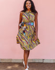 The model is wearing multi-colored abstract print dress