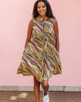 The model is wearing multi-colored abstract print dress