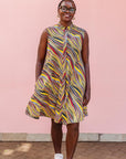 The model is wearing multi-colored abstract print dress