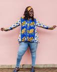 The model is wearing white, blue, black and orange mixed pattern long sleeved kanga shirt