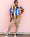 The model is wearing black, white, orange and blue mixed pattern kanga shirt