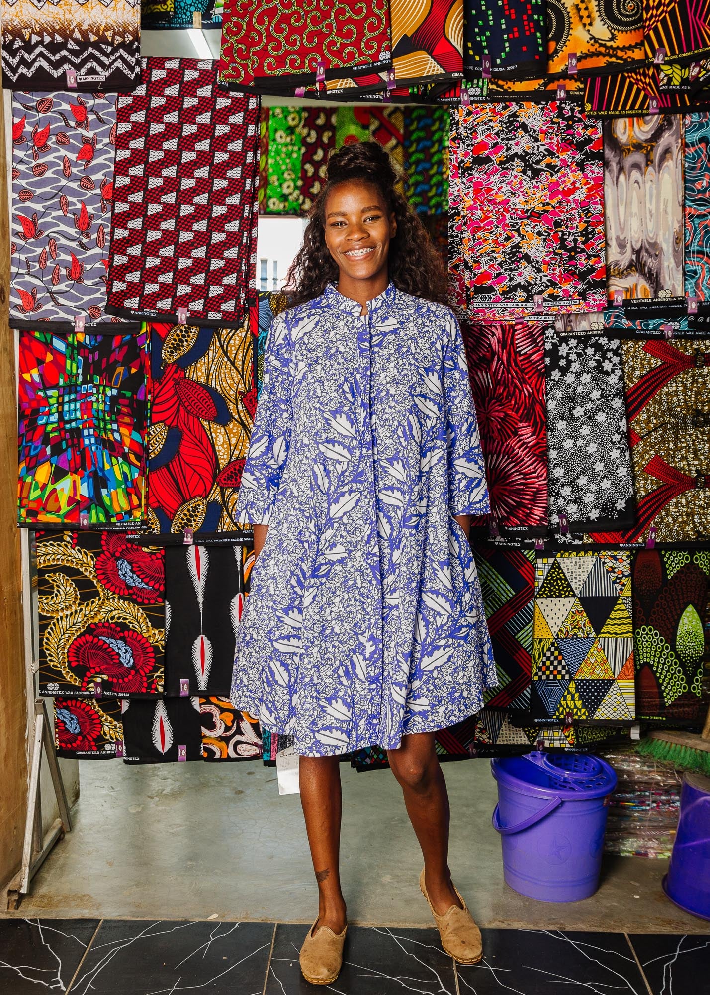 The model is wearing violet and white leaf print dress