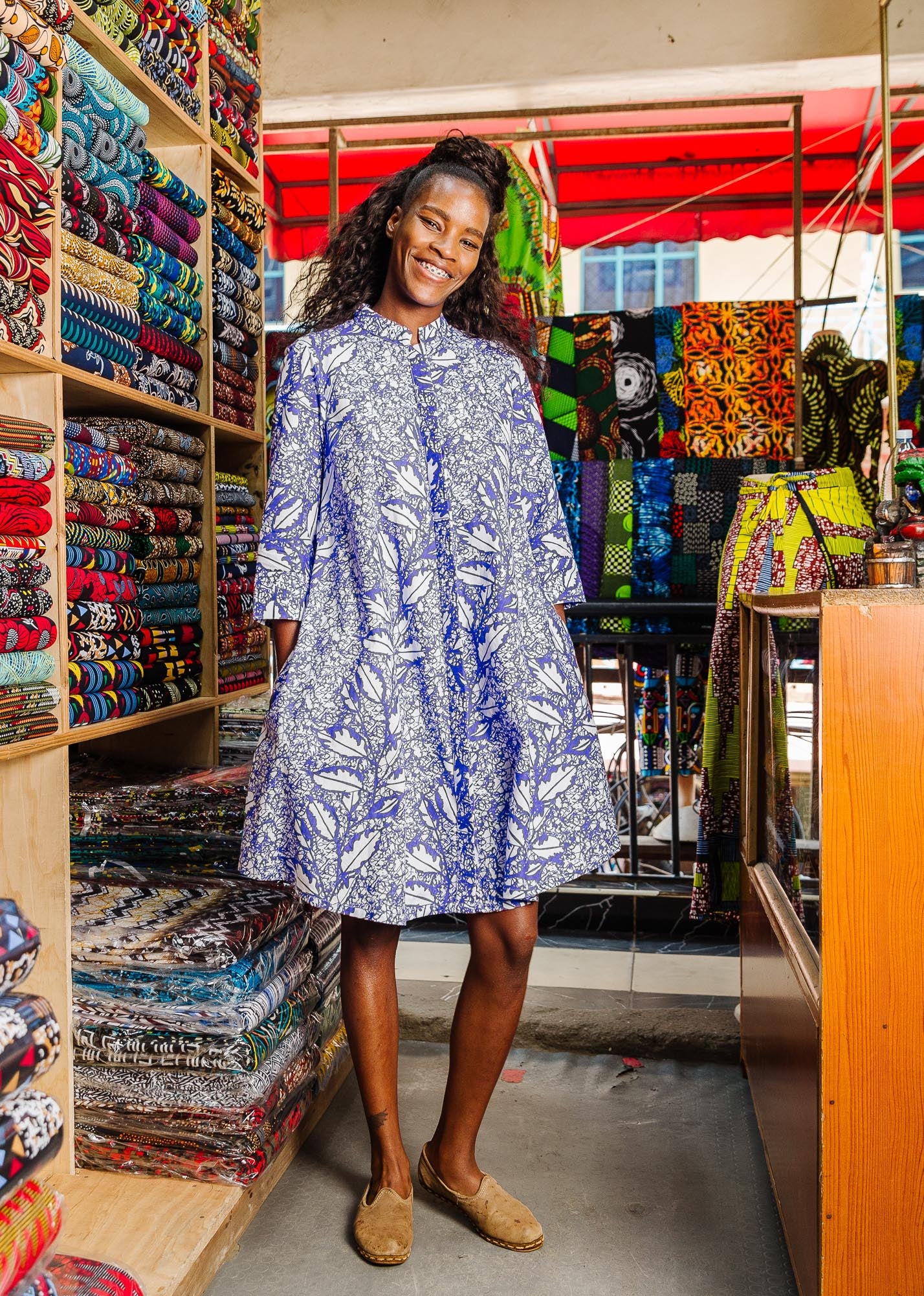 The model is wearing violet and white leaf print dress