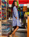 The model is wearing violet and white leaf print dress