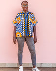 The model is wearing black, white, orange and blue mixed pattern kanga shirt