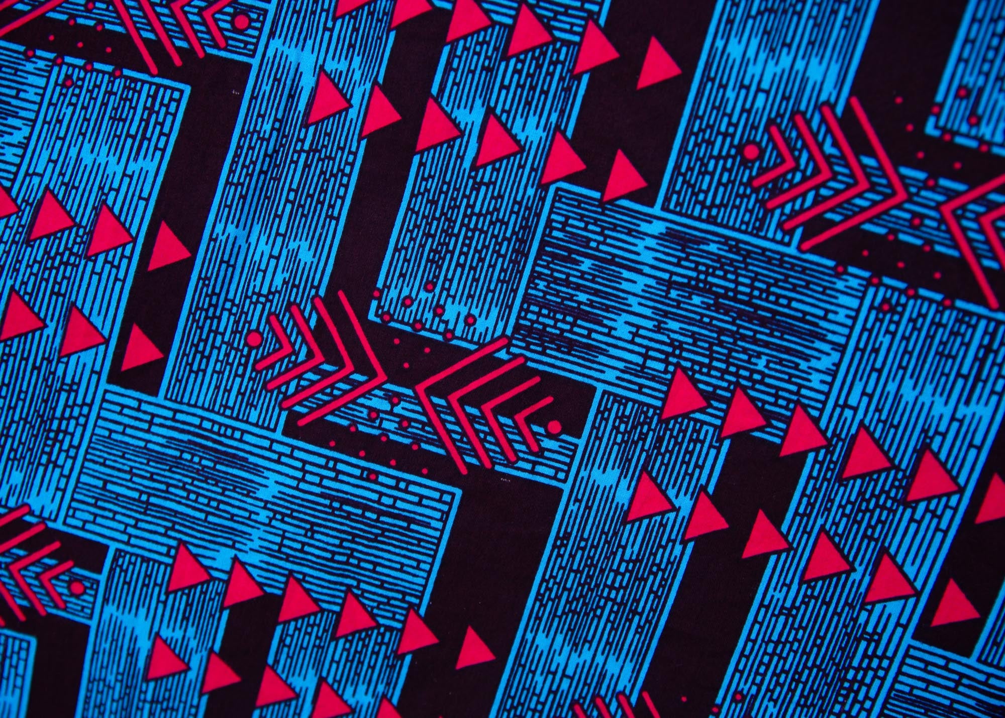 Close up display of black, blue and hot pink geometric print dress