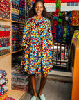 The model is wearing multi colored geometric print dress