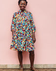 The model is wearing multi colored geometric print dress