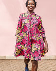 The model is wearing black, white, yellow, brown, pink, hot pink and purple bubble print dress