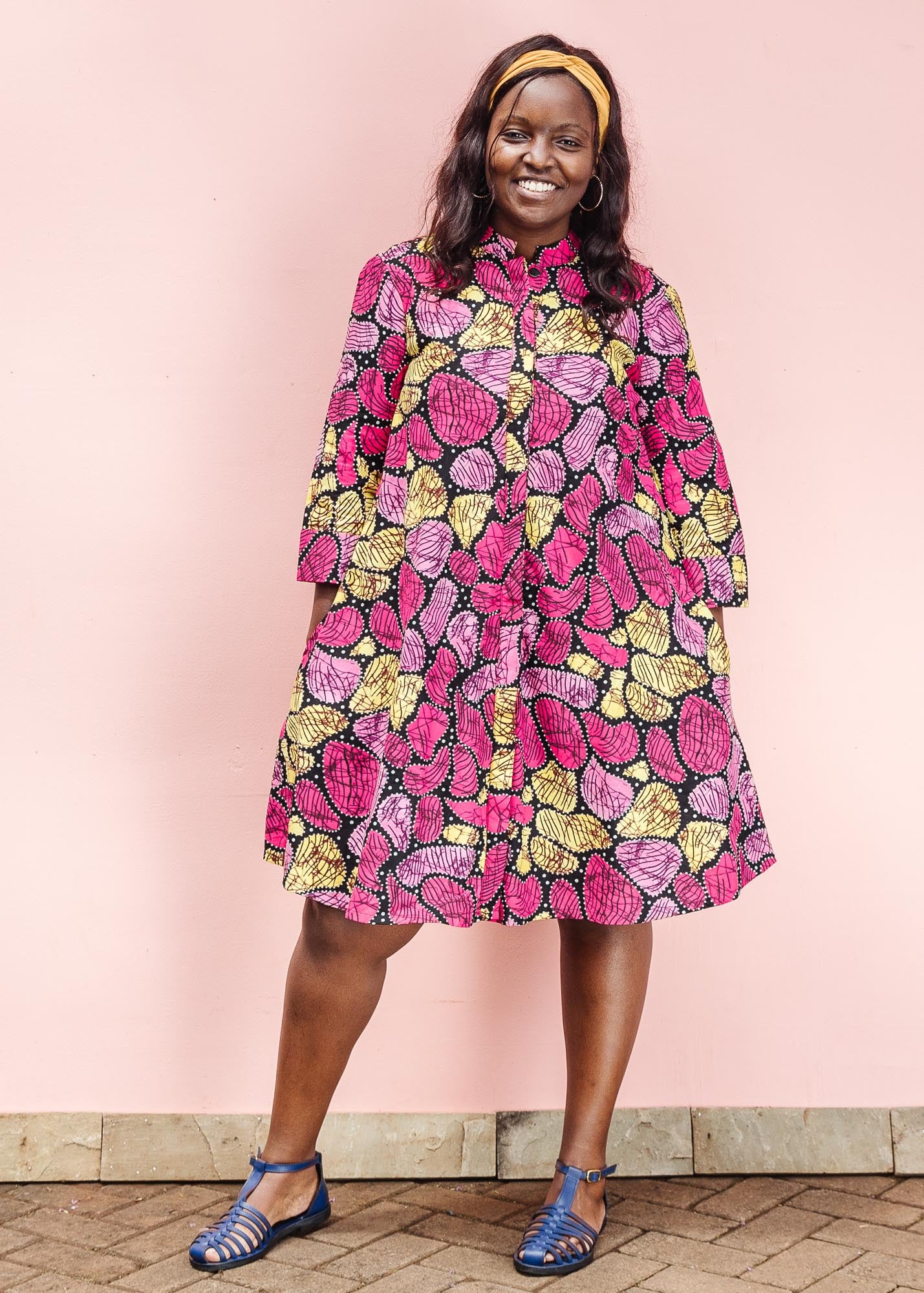 The model is wearing black, white, yellow, brown, pink, hot pink and purple bubble print dress