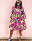 The model is wearing black, white, yellow, brown, pink, hot pink and purple bubble print dress