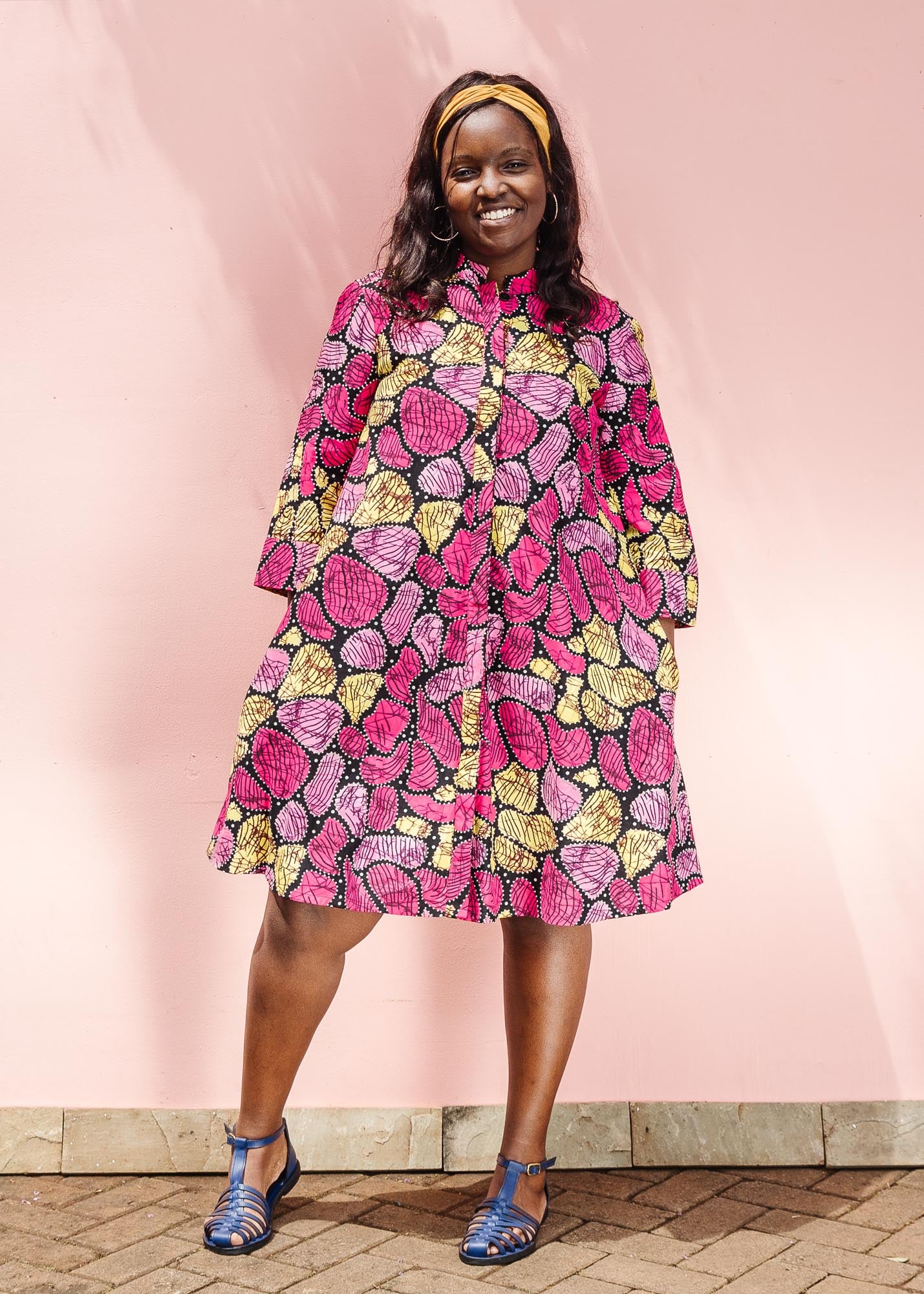 The model is wearing black, white, yellow, brown, pink, hot pink and purple bubble print dress