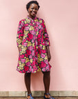 The model is wearing black, white, yellow, brown, pink, hot pink and purple bubble print dress