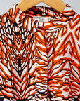 Display of orange, black and white abstract print long sleeved shirt