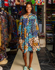 The model is wearing black dress with yellow dots and brown, blues, peach leaves.