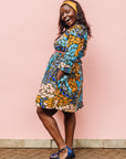 The model is wearing black dress with yellow dots and brown, blues, peach leaves.