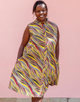 The model is wearing multi-colored abstract print dress