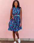 The model is wearing black, blue and hot pink geometric print dress