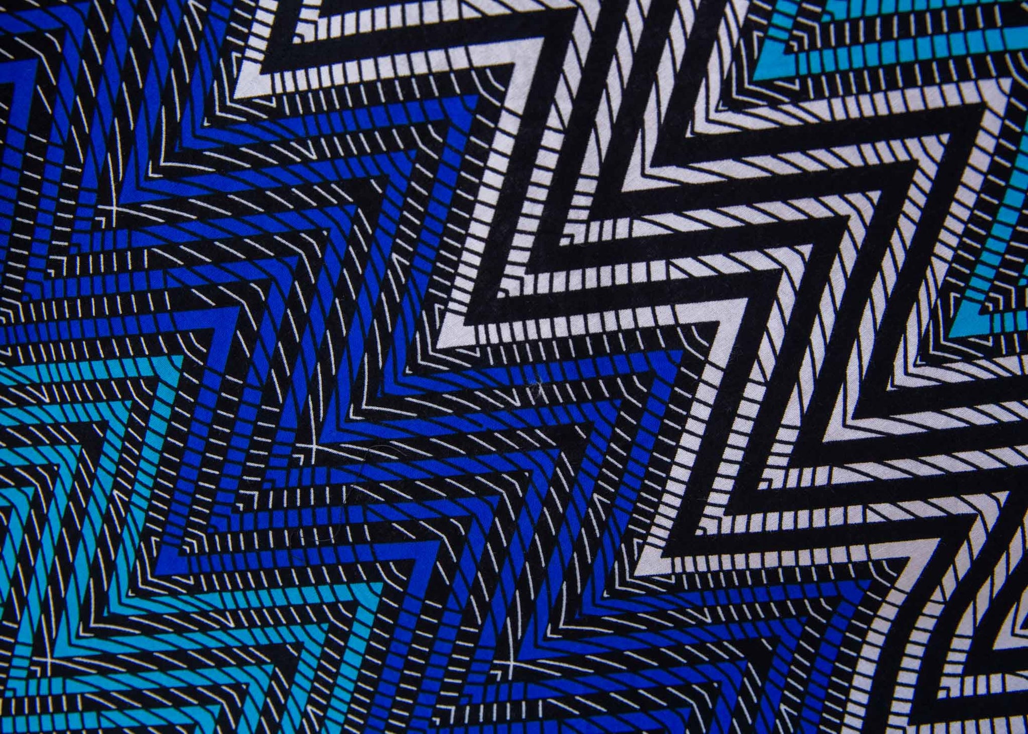 Close up display of blue, aqua and white zig zag print dress, fabric.