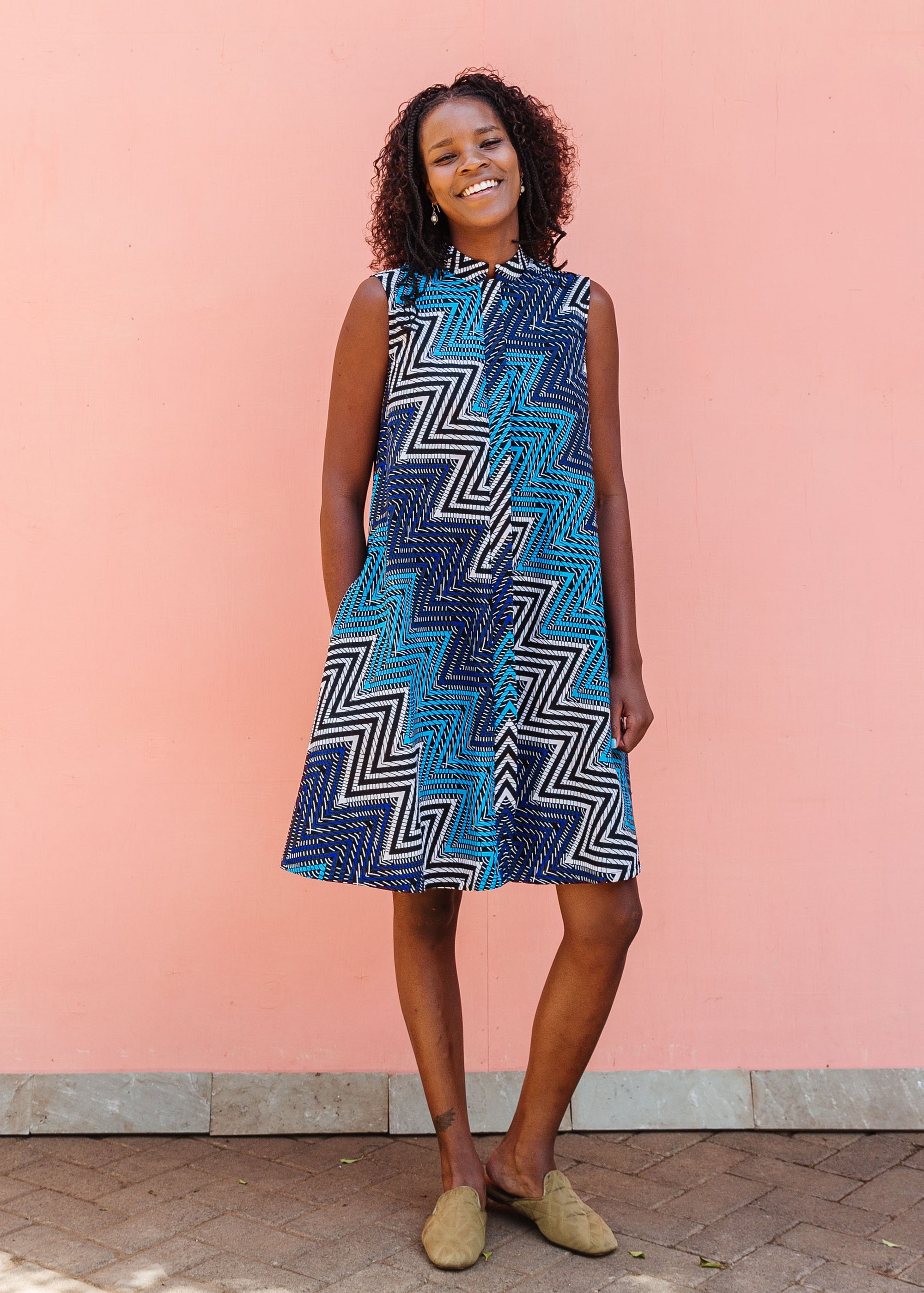 Model wearing blue, aqua and white zig zag print dress.