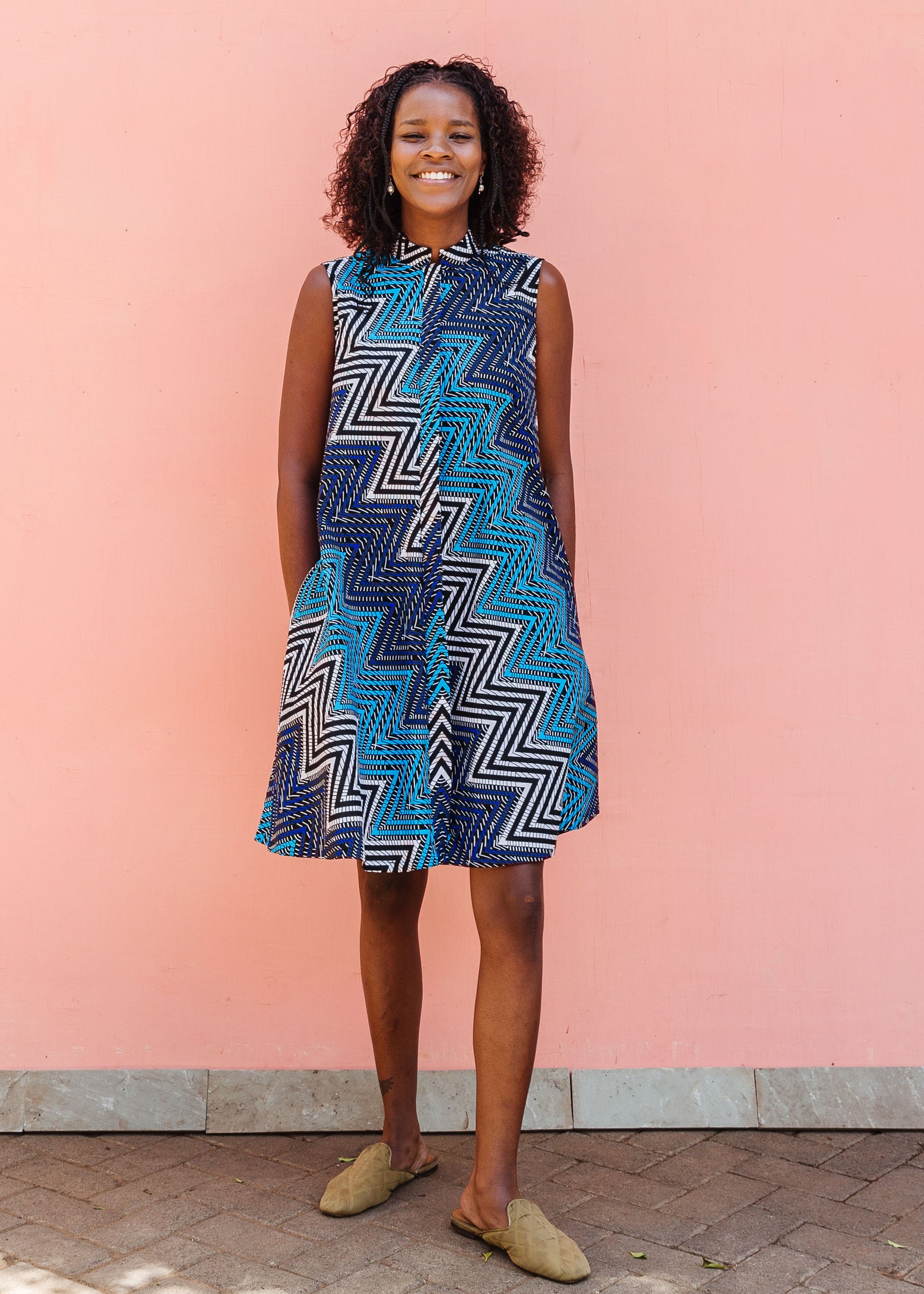 Model wearing blue, aqua and white zig zag print dress.