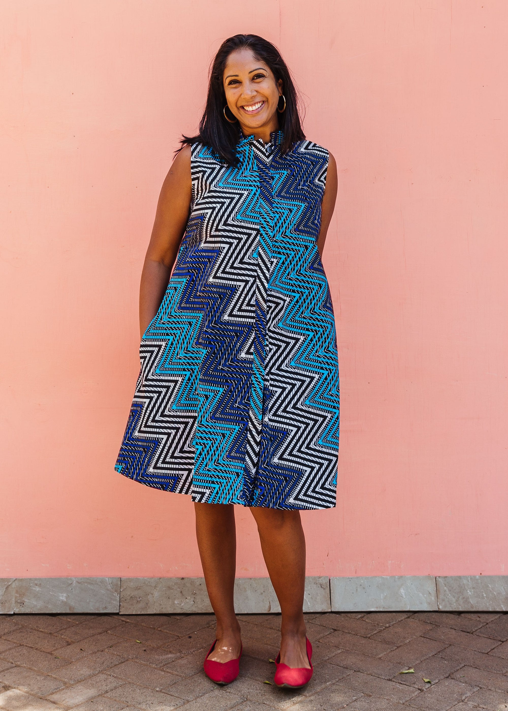 Model wearing blue, aqua and white zig zag print dress.