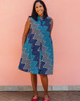 Model wearing blue, aqua and white zig zag print dress.